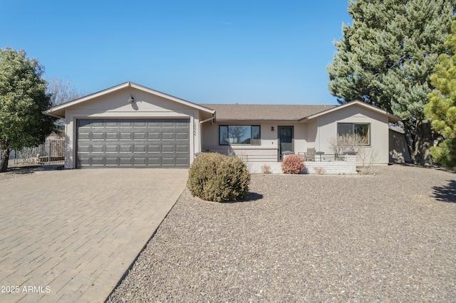 ranch-style home with a garage and decorative driveway