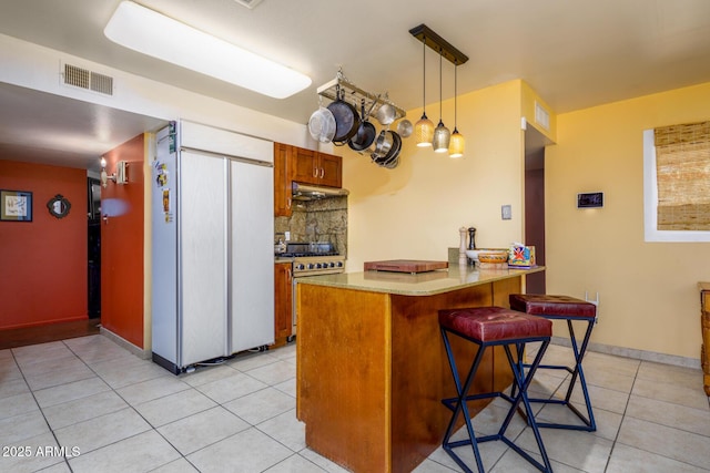 15212 N 37th Ave, Phoenix, AZ 85053 - kitchen with a breakfast bar area, high quality appliances, visible vents, a peninsula, and under cabinet range hood