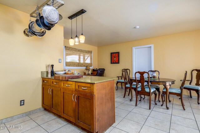 15212 N 37th Ave, Phoenix, AZ 85053 - kitchen featuring brown cabinetry, hanging light fixtures, light countertops, light tile patterned floors, and a peninsula