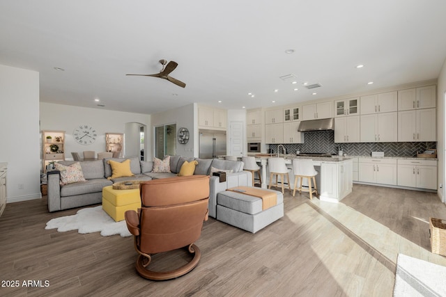 living room featuring ceiling fan and light wood-type flooring