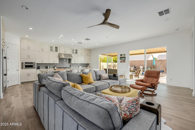 living room with light hardwood / wood-style floors and ceiling fan