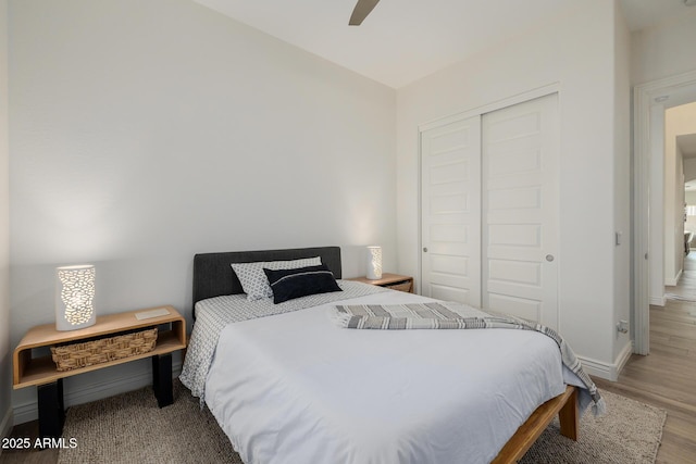 bedroom with ceiling fan, light wood-type flooring, and a closet