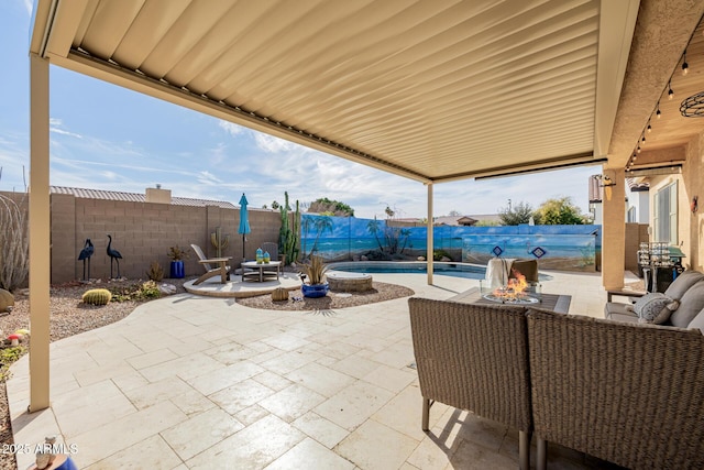 view of patio / terrace featuring a fenced in pool and an outdoor fire pit