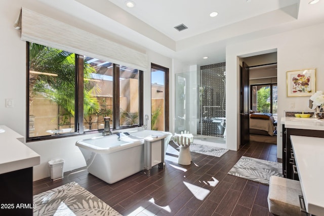 bathroom with vanity, a tray ceiling, and shower with separate bathtub