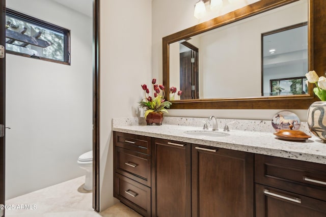 bathroom with vanity, a healthy amount of sunlight, and toilet