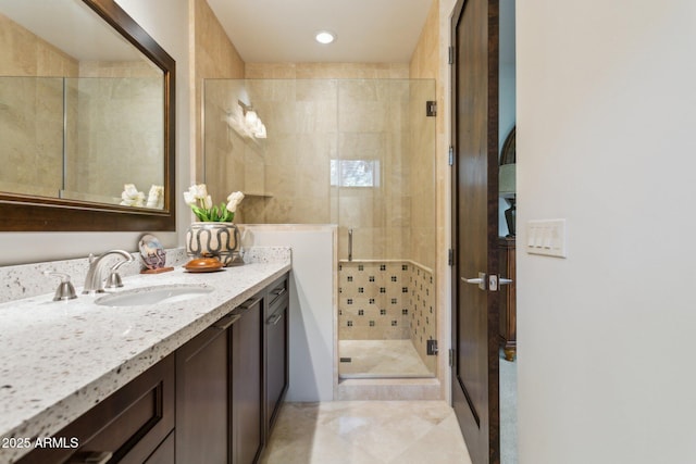 bathroom featuring a shower with door and vanity