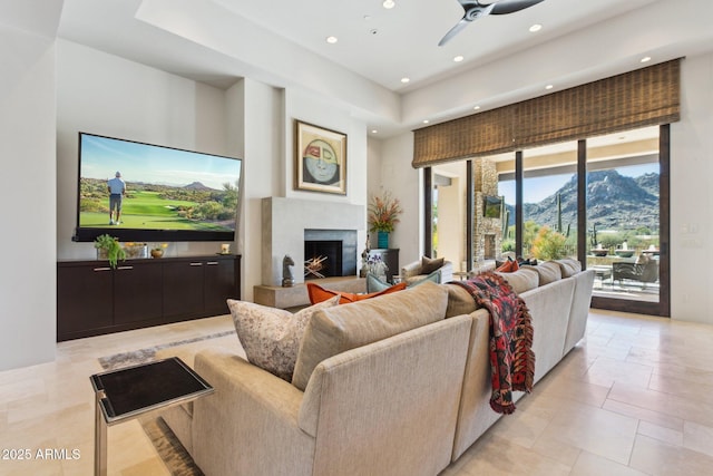 living room with a mountain view, a fireplace, and ceiling fan