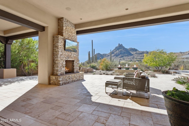 view of patio with a mountain view and an outdoor stone fireplace