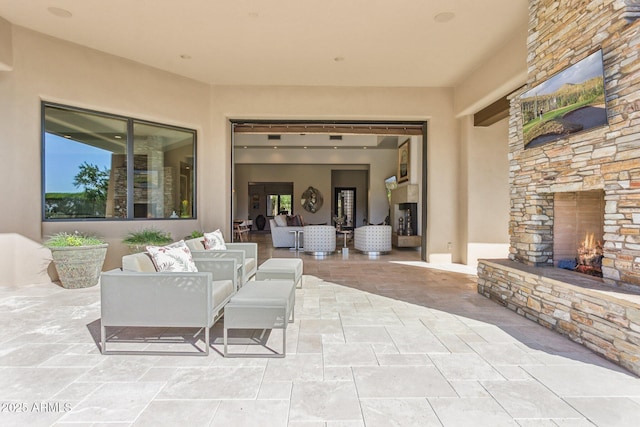 view of patio with an outdoor living space with a fireplace