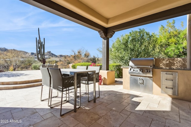 view of patio / terrace featuring an outdoor kitchen, a grill, and a mountain view