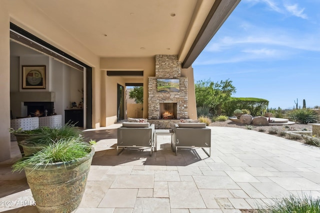 view of patio / terrace featuring an outdoor stone fireplace