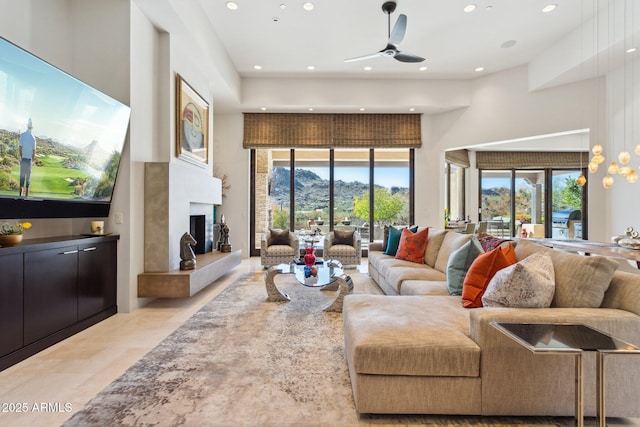 living room featuring plenty of natural light, ceiling fan, and a high ceiling