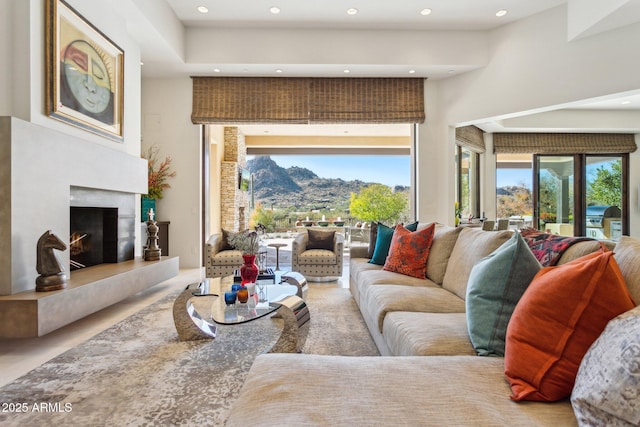 living room featuring a mountain view, a fireplace, a high ceiling, and plenty of natural light