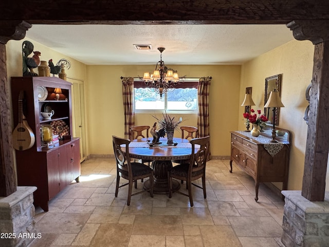 dining space featuring a textured ceiling and a notable chandelier