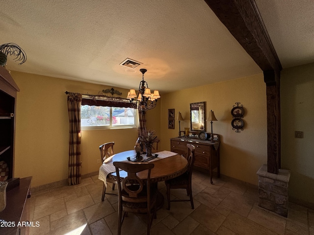 dining area featuring a textured ceiling and an inviting chandelier