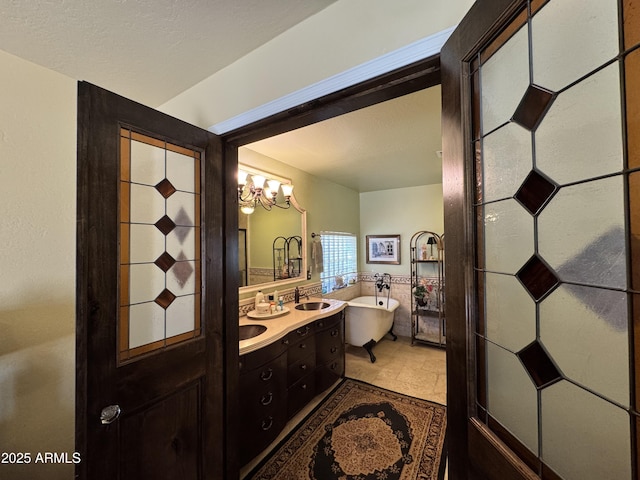 bathroom with vanity, a bathing tub, and an inviting chandelier