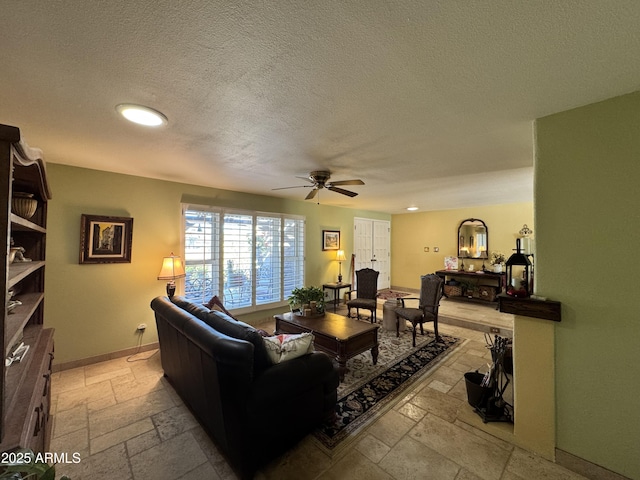 living room featuring a textured ceiling and ceiling fan