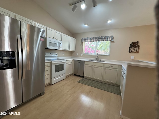 kitchen featuring light hardwood / wood-style flooring, sink, stainless steel appliances, lofted ceiling, and track lighting