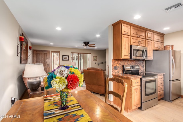 kitchen featuring light hardwood / wood-style floors, stainless steel appliances, ceiling fan, backsplash, and stone countertops