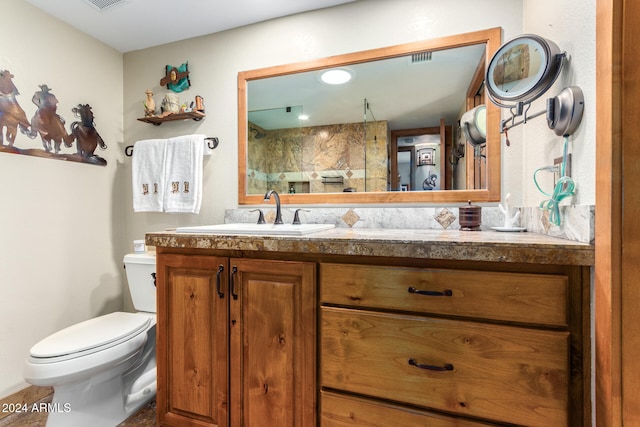 bathroom featuring walk in shower, vanity, and toilet