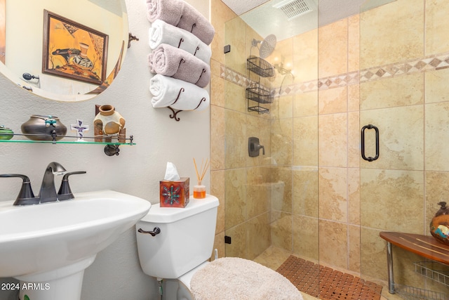 bathroom featuring a textured ceiling, sink, toilet, and a shower with door