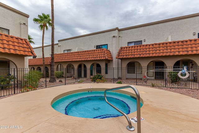 view of swimming pool featuring a hot tub and a patio area