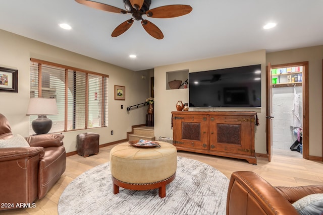 living room with ceiling fan and light hardwood / wood-style flooring