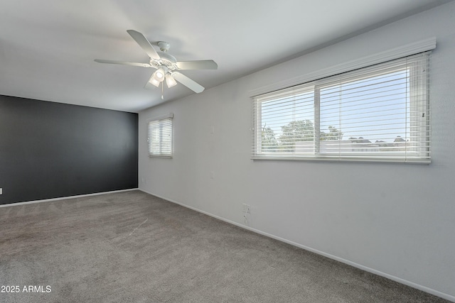 carpeted empty room featuring baseboards, a healthy amount of sunlight, and a ceiling fan