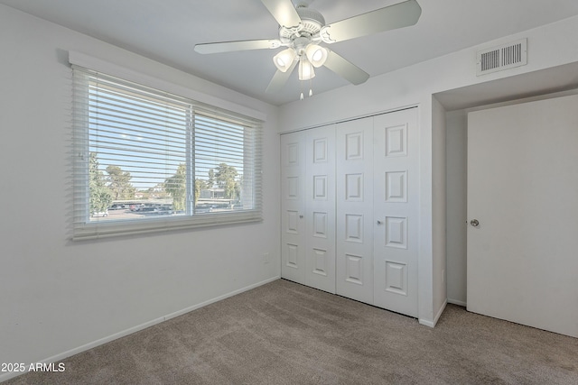 unfurnished bedroom with visible vents, baseboards, ceiling fan, carpet flooring, and a closet