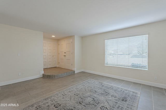 unfurnished room with recessed lighting and baseboards