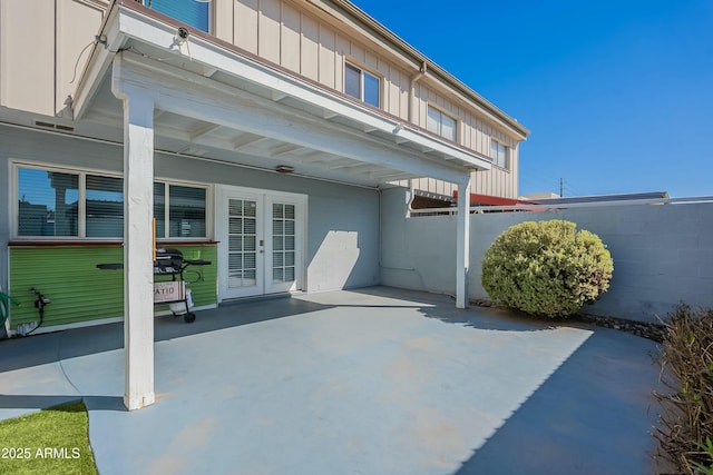 view of patio featuring french doors and fence