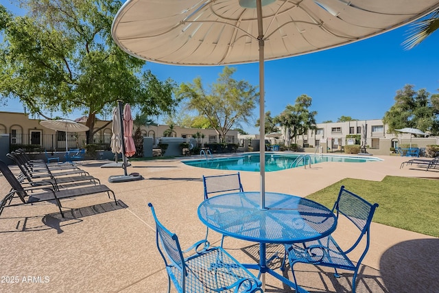 community pool featuring a yard, a patio, and fence