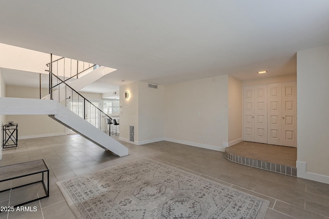 tiled foyer with visible vents, baseboards, and stairs