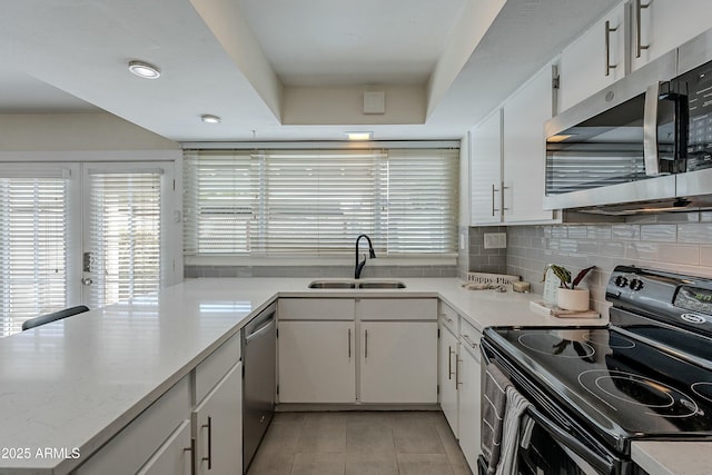 kitchen with light tile patterned floors, a sink, stainless steel appliances, light countertops, and white cabinetry