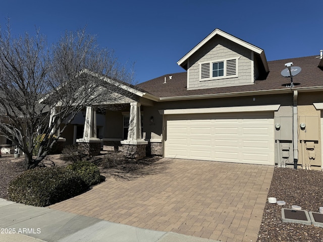 craftsman-style house featuring a garage and decorative driveway