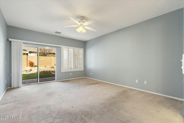 carpeted spare room featuring ceiling fan and baseboards