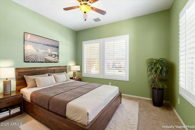 bedroom with a ceiling fan, light colored carpet, visible vents, and baseboards