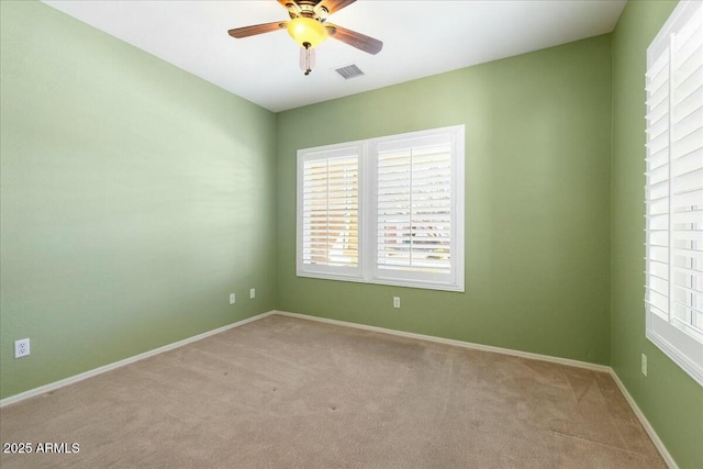 spare room featuring ceiling fan, baseboards, visible vents, and light colored carpet