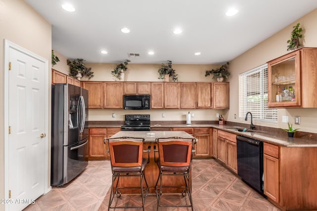 22022 W Moonlight Path, Buckeye, AZ 85326 - kitchen with black appliances, a sink, a center island, recessed lighting, and a breakfast bar area
