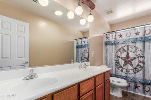 22022 W Moonlight Path, Buckeye, AZ 85326 - bathroom featuring toilet, wood finished floors, double vanity, and a shower with curtain