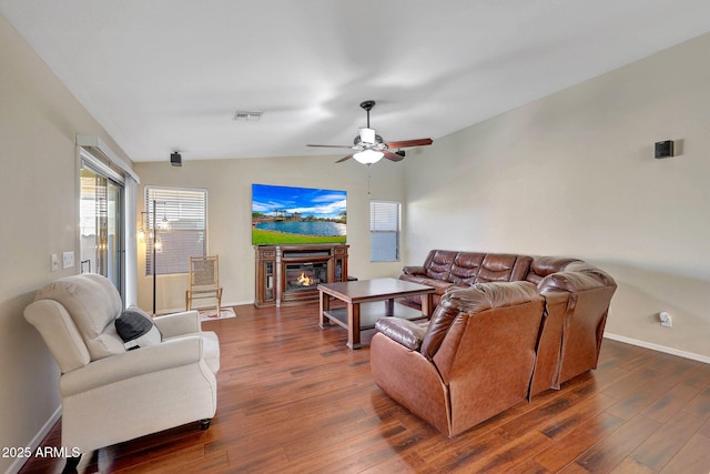9926 W Gross Ave, Tolleson, AZ 85353 - living area with dark wood-style flooring, vaulted ceiling, a ceiling fan, and a glass covered fireplace