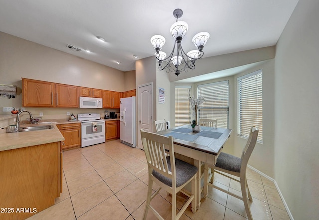 9926 W Gross Ave, Tolleson, AZ 85353 - kitchen with white appliances, light countertops, light tile patterned flooring, and a chandelier