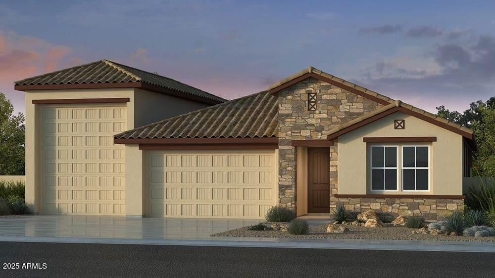 5208 W Jackalope Ln, Laveen, AZ 85339 - view of front facade with stone siding, an attached garage, stucco siding, and concrete driveway