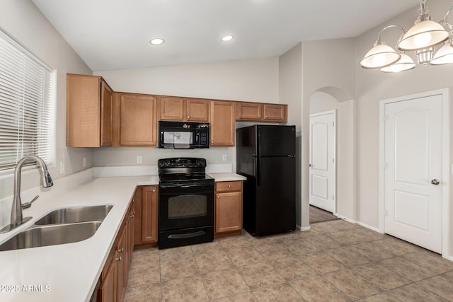 kitchen featuring brown cabinetry, black appliances, vaulted ceiling, and a sink