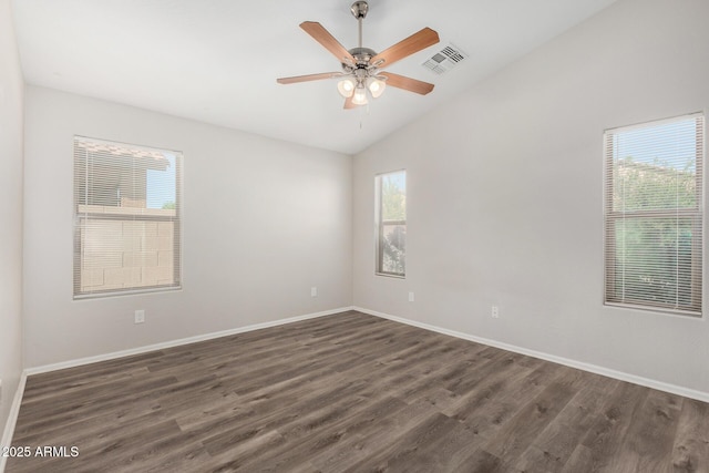 unfurnished room featuring baseboards, vaulted ceiling, visible vents, and dark wood-type flooring