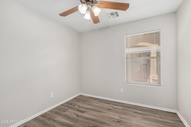 spare room featuring ceiling fan, baseboards, wood finished floors, and visible vents