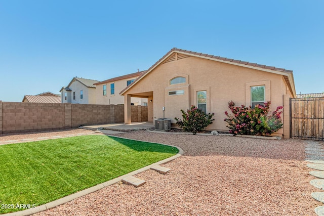 back of house with a yard, a patio, a fenced backyard, and stucco siding