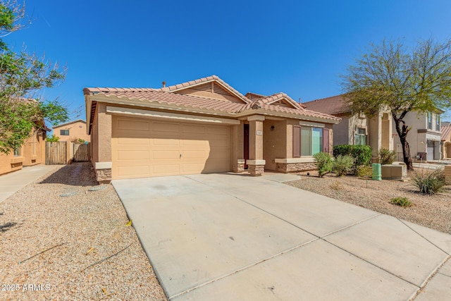 view of front of house with stucco siding, stone siding, a tiled roof, and a garage