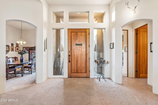 entryway with a high ceiling and a chandelier