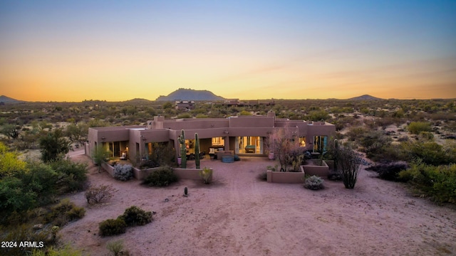 back house at dusk featuring a mountain view